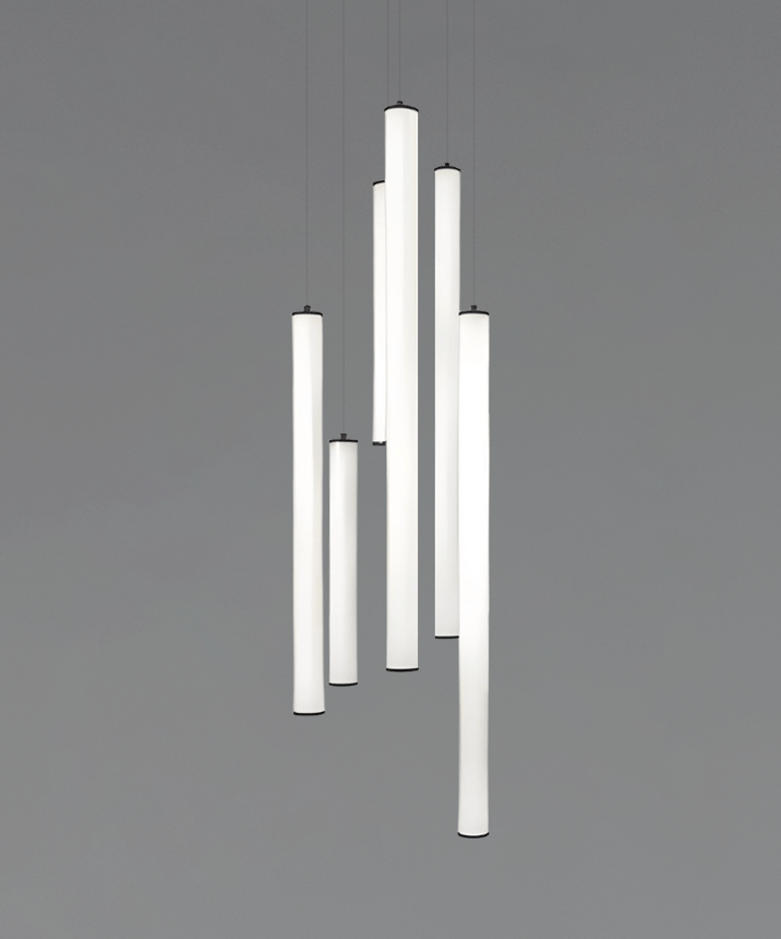 Alcon 12146-6R Suspended commercial vertical cylinder pendant shown with slim black end caps and 360 wrapping illuminated lens. Shown in a set of 6 at various lengths.
