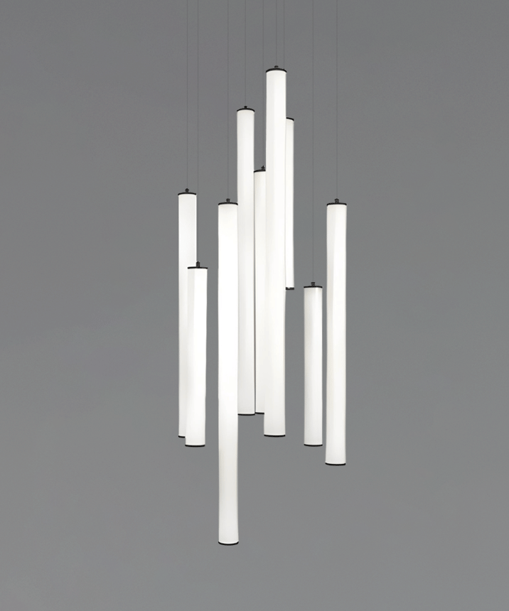 Alcon 12146-9R Suspended commercial vertical cylinder pendant shown with slim black end caps and 360 wrapping illuminated lens. Shown in a set of 9 at various lengths.
