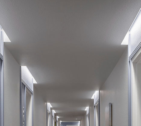 Fixed-length cove lights illuminate unit entries in a Wilton Court Apartments corridor, creating a high-end residential appearance.