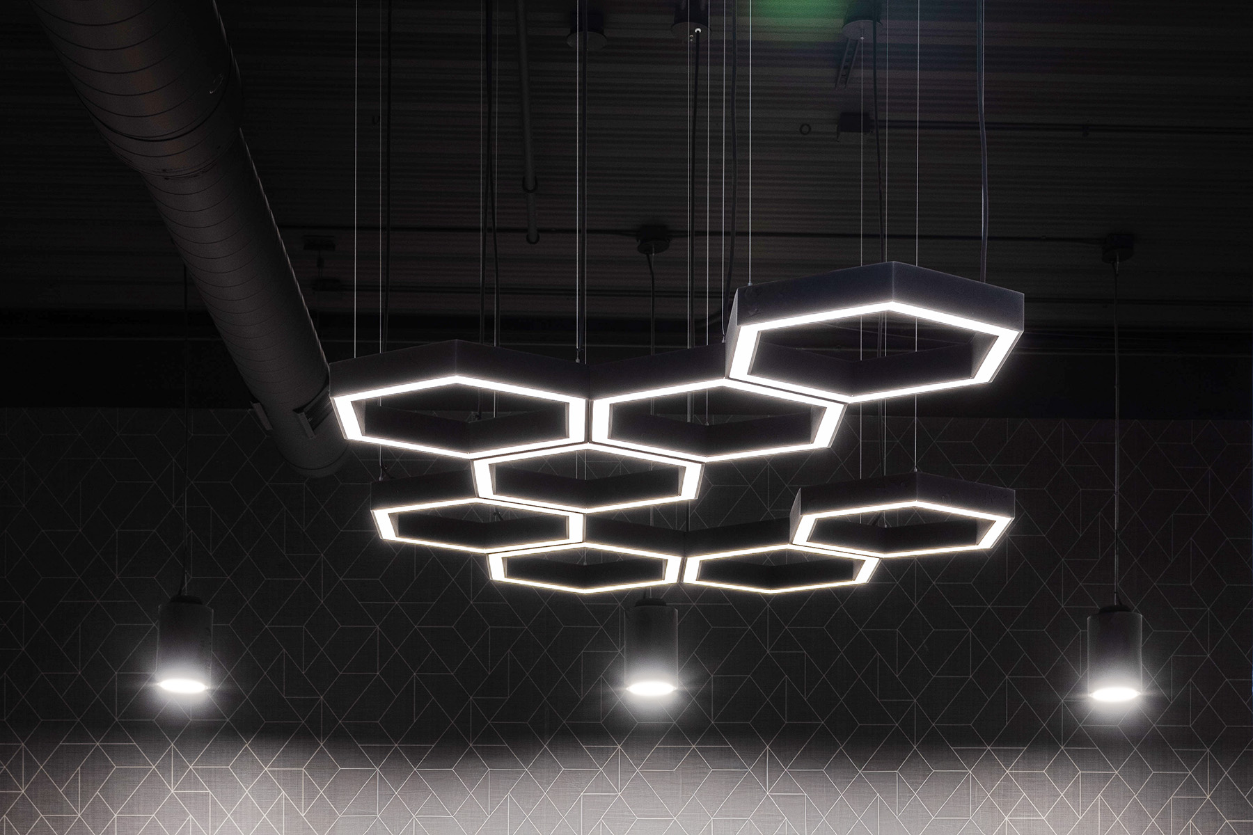 A hexagon pendant LED light set in a unique honeycomb pattern with a soft white 3000K color temperature.