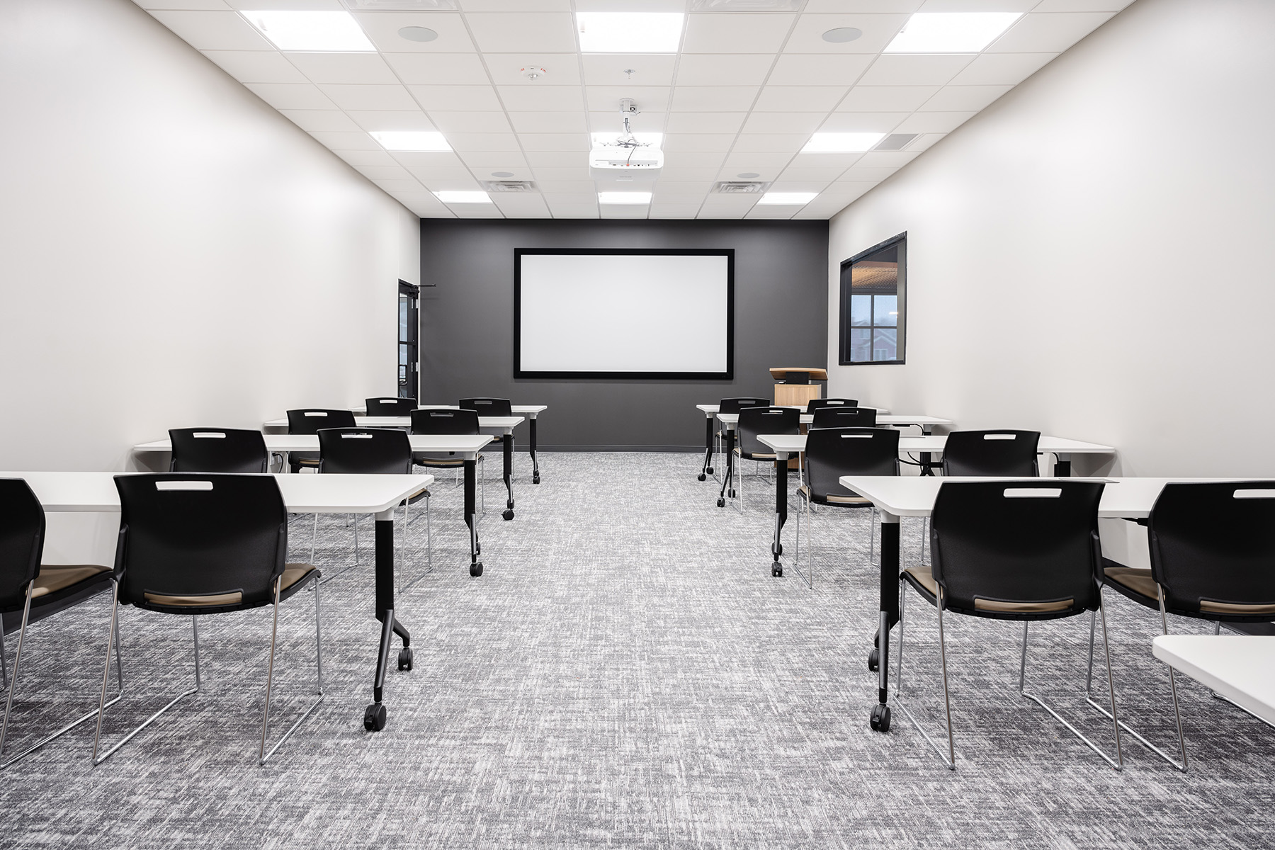 LED troffer lights offer bright task lighting to help employees learn in an office training room.