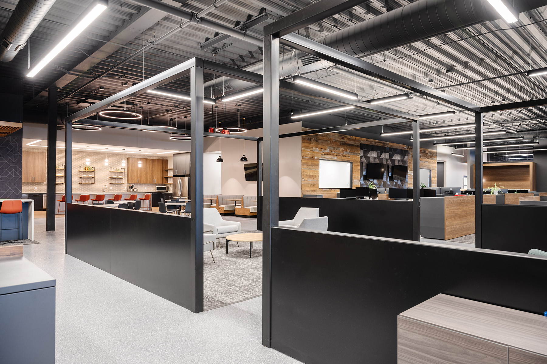 An open floor plan office can use lighting to create distinctive spaces, with linear pendants over desks and meeting areas and decorative pendants in break areas.